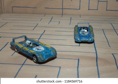 Athens, Greece – December 15, 2016: Old Matchbox Toy Cars Of The 70’s, Parked On A Wooden Deck With The Pattern Of A Labyrinth, Designed With A Blue Pen.