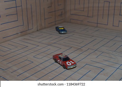 Athens, Greece – December 15, 2016: Old Matchbox Toy Cars Of The 70’s, Parked On A Wooden Deck With The Pattern Of A Labyrinth, Designed With A Blue Pen.