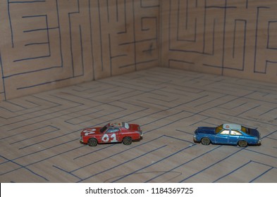 Athens, Greece – December 15, 2016: Old Matchbox Toy Cars Of The 70’s, Parked On A Wooden Deck With The Pattern Of A Labyrinth, Designed With A Blue Pen.