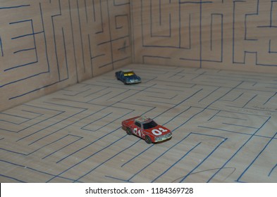 Athens, Greece – December 15, 2016: Old Matchbox Toy Cars Of The 70’s, Parked On A Wooden Deck With The Pattern Of A Labyrinth, Designed With A Blue Pen.