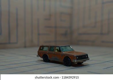 Athens, Greece – December 15, 2016: Old Matchbox Toy Car. A Green Volvo Station Wagon Of The 70’s, Running On A Wooden Deck With The Pattern Of A Labyrinth, Designed With A Blue Pen.