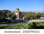 Athens, Greece - December 19, 2023: Holy Church of the Holy Apostles of Solakis, located in the Ancient Agora of Athens dated to late 10th century and view to Temple of Hephaistos and observatory