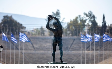 Athens, Greece. Discus thrower bronze statue, discobolus sculpture, Panathenaic Stadium blur background. Male athlete body rear view - Powered by Shutterstock