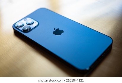 ATHENS, GREECE - JULY 2022: Shot of new Apple iPhone 12 Pro Max blue color Isolate on golden background