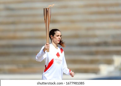 Athens, Greece - March 19, 2020: Olympic Flame handover ceremony for the Tokyo 2020 Summer Olympic Games. Greek Olympic medalist  K. Stefanidi holds the Tokyo Olympic Flame at the Panathenaic stadium