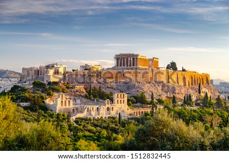 ATHENS, GREECE – NOVEMBER 4, 2018: Famous Athens landmark Acropolis and the Odeon of Herodes Atticus, Herodeion, just after the sunrise. View from Filopappou Hill with lots of olive trees and conifers