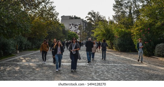 Athens, Greece - Oct 10, 2018. People Walking On The Cobblestone Road In Athens, Greece. Athens Is A Tourist Attraction That Loves History And Archeology.