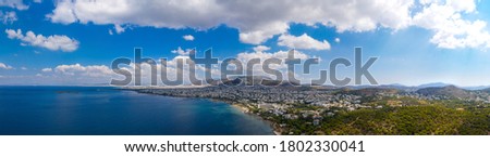 Athens Greece riviera panorama. Aerial drone view of Voula and Glyfada coastline, high class residential distric. Cloudy blue sky over sea water, sunny summer day