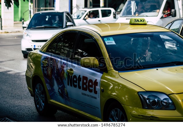 Athens Greece\
September 4, 2019 View of Greek yellow taxi driving through the\
streets of Athens in the\
morning