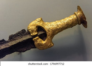 Athens - May 7, 2018: Bronze sword with gold hilt revetment from Greek Mycenae in National Archaeological Museum of Athens, Greece. Golden artifact, jewelry and history of ancient civilization.