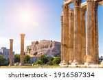 Athens view, Zeus temple overlooking Acropolis, Greece. Ancient Greek ruins, famous landmarks of Athens city. Scenery of great columns of classical building in Athens center. Travel in Greece theme.