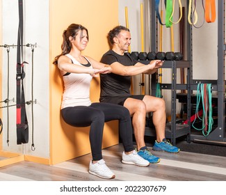 Athete people doing squats leaning on wall in gym - Powered by Shutterstock