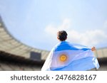 An athlete with the Argentine flag draped over their shoulders, representing Argentina in the stadium during a major international sporting event.