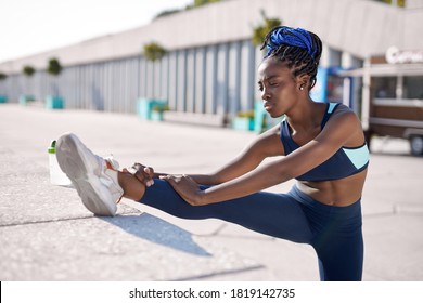 athlete black afro woman stretching hamstring leg muscles during outdoor running workout, african sport fitness model in city - Powered by Shutterstock