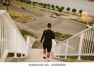 An Athlete In Black Gear Runs Down The Stairs 