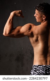 Athlete bodybuilder trains in the studio in the rain. - Shutterstock ID 2284230797