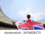 An athlete with the British flag draped over their shoulders, representing the United Kingdom in the stadium during a major international sporting event.