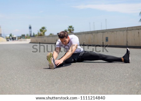 Athlete at the city park warming and stretching