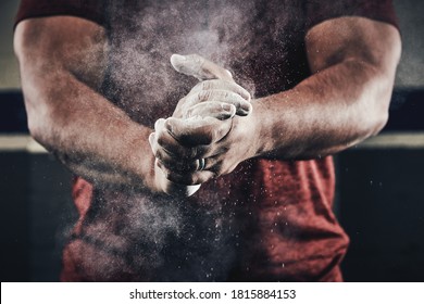 Athlete clapping hands with chalk dust for weight lifting