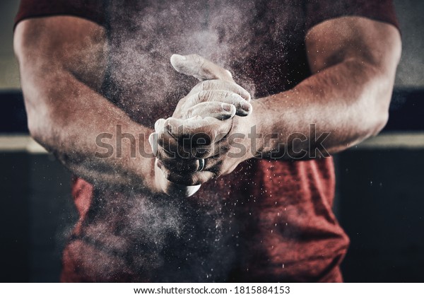 Athlete\
clapping hands with chalk dust for weight\
lifting