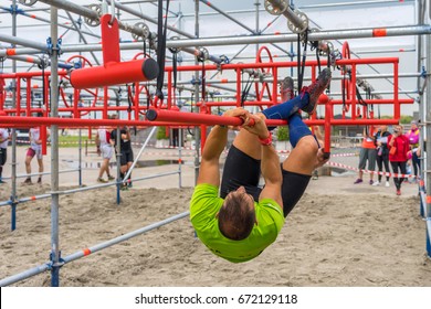 Athlete Climbing Along A Pole At An Obstacle Course Race
