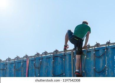 Athlete climbing over a container at an obstacle course race 