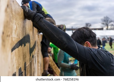 Athlete climbing over a wooden wall at an obstacle course race