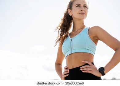 An athlete in comfortable sportswear. Outdoor fitness in the city. Healthy lifestyle. Coach exercises on the street. A confident woman does a workout.