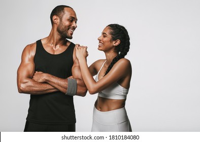 Athlete Couple Having Fun After Workout. Smiling Woman Talking To Male Friend At The Gym.