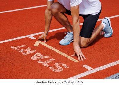 Athlete crouched at starting line ready to sprint on track. Sports, competition, focus, fitness, race. - Powered by Shutterstock