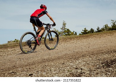 Athlete Cyclist Riding Uphill Trail On Mountain Bike