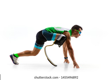 Athlete With Disabilities Or Amputee Isolated On White Studio Background. Professional Male Runner With Leg Prosthesis Training And Practicing In Studio. Disabled Sport And Healthy Lifestyle Concept.