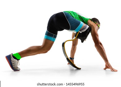 Athlete With Disabilities Or Amputee Isolated On White Studio Background. Professional Male Runner With Leg Prosthesis Training And Practicing In Studio. Disabled Sport And Healthy Lifestyle Concept.