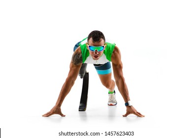 Athlete With Disabilities Or Amputee Isolated On White Studio Background. Professional Male Runner With Leg Prosthesis Training And Practicing In Studio. Disabled Sport And Healthy Lifestyle Concept.