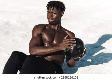 Athlete Doing Exercises For The Abdomen On The Floor. Man Doing Workout With Medicine Ball, Outdoors