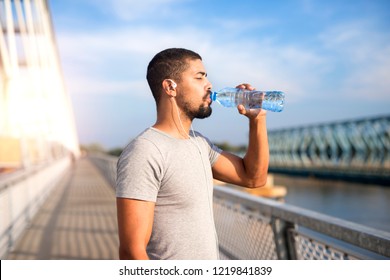 An athlete drinking water after hard training. Body hydration for healthy lifestyle. Fitness and running.