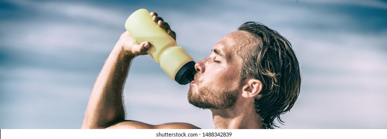 Athlete drinking water bottle during intense training workout sweating in summer heat. Man runner thirst quenching hydration sports bottle drink panoramic banner. - Powered by Shutterstock