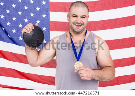 Athlete with game gold medal and american flag in background