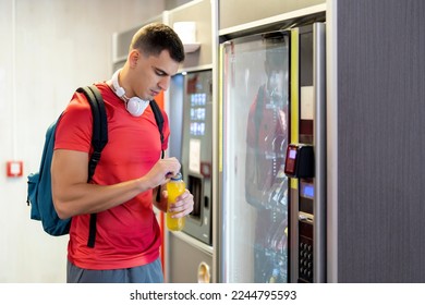 Athlete in gym consuming drink from food vending machine