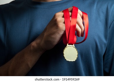 Athlete Holding Gold Medal With His Hands. Medal Concept.