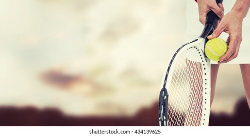 Athlete holding a tennis racquet ready to serve against composite image of landscape - Powered by Shutterstock