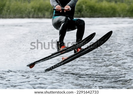 athlete jump waterskiing behind motor boat on lake, extreme summer water sports