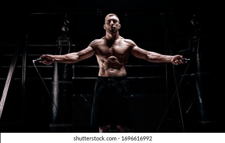 The athlete jumps on a skipping rope in the gym opposite the boxing ring. The concept of sport, bodybuilding, fitness, healthy lifestyle. Mixed media - Powered by Shutterstock