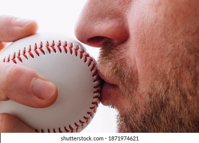 Athlete kisses a baseball for good luck before throwing - pitcher performs ritual while playing