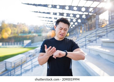 Athlete Looks At Watch Asian Man Disappointed With His Result Running Time And Calories Burned After Training And Running