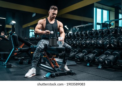 athlete man preparing protein cocktail or use sport nutrition supplement in gym - Shutterstock ID 1903589083