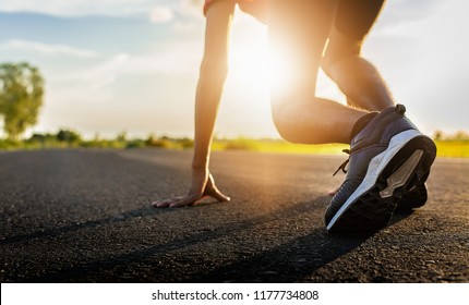 Athlete Man In Running Start Pose On The Road.