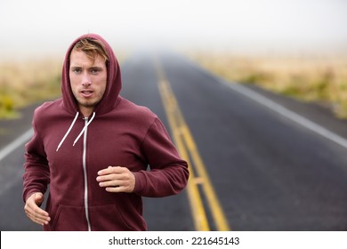 Athlete man running training on road in fall in sweatshirt hoodie in autumn. Male runner training outdoors jogging in nature. - Powered by Shutterstock