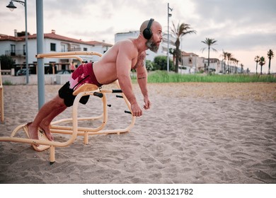 Athlete Man Training While Doing Calisthenics Exercises Outdoors At The Beach.