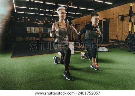 Athlete man and woman performing exercises with resistance bands in the gym